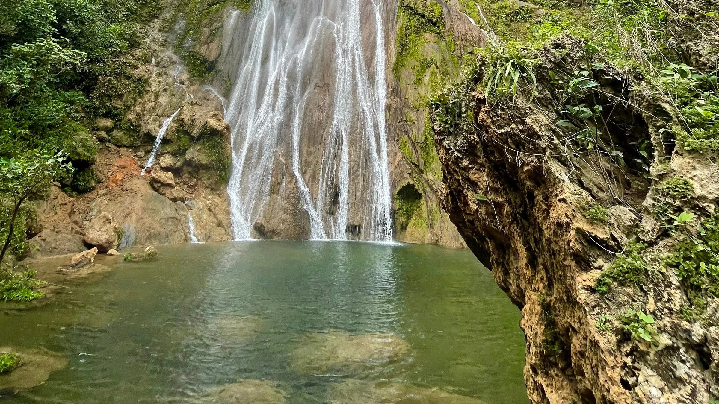 Cachoeira da Boca da Onça caindo pelo paredão de pedra até uma lagoa verde, em Bodoquena